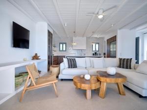 a living room with a white couch and a table at Villa Katy in Aspro Chorio Paros