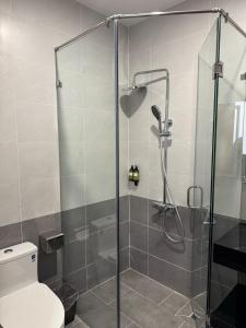 a bathroom with a glass shower with a toilet at Khách sạn Lâm Hà - Laha Hotel in Riong Serignac