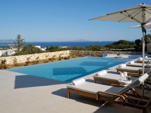 a swimming pool with lounge chairs and an umbrella at Villa Katy in Aspro Chorio Paros