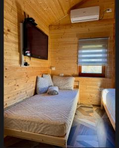 a bedroom with a bed in a wooden cabin at Drveni san Senović 2 in Banja