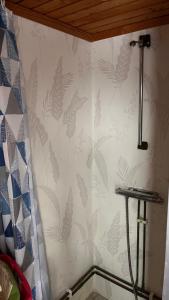 a bathroom with a wall with a leafy wallpaper at Cozy farmhouse with rowboat! in Skönberga +22 photos