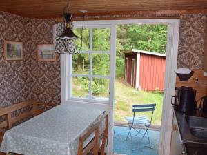a kitchen with a table and a view of a barn at Cozy farmhouse with rowboat! in Skönberga