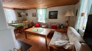 a living room with a couch and a table at Cozy farmhouse with rowboat! in Skönberga