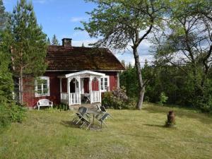 a red house with chairs in front of it at Cozy farmhouse with rowboat! in Skönberga