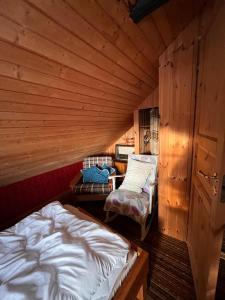 a room with two beds in a wooden cabin at Cozy farmhouse with rowboat! in Skönberga
