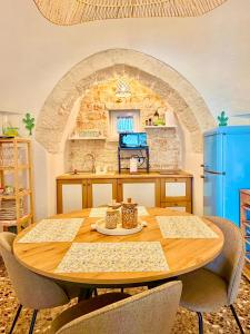 a kitchen with a wooden table with chairs around it at Trulli Fenice in Martina Franca