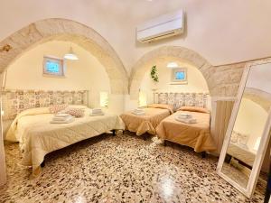a bedroom with two beds and two mirrors at Trulli Fenice in Martina Franca +51 photos