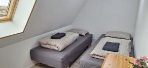 two beds in a small room with a table at Cottage in the middle of nowhere in Ölfus