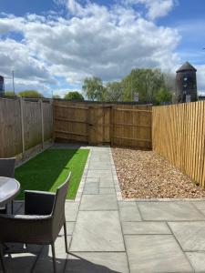 a garden with a fence and a table and chairs at Cute Central House Sleeps 4 in Stafford