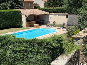 a swimming pool in a yard next to a house at Le Clos de Narco in Vernosc-lès-Annonay