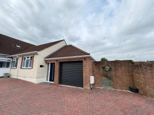 a brick house with a garage with a brick wall at Teran the apartment in Timsbury