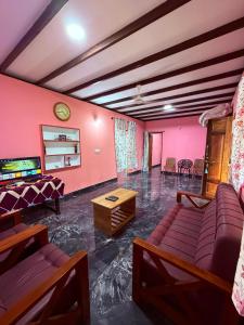a living room with a couch and a tv at Dishaa Estate View Home Stay in Madikeri