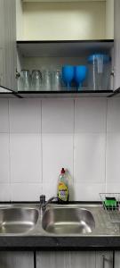 a kitchen counter with a sink and glasses on a shelf at AMBROZIA Apartment-self catering-2bed2bath in Bloemfontein +41 photos