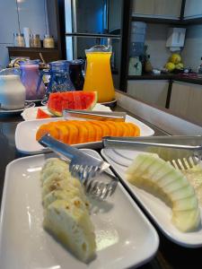 a table with plates of food with fruit on it at Pousada Mel e Mar in Penha