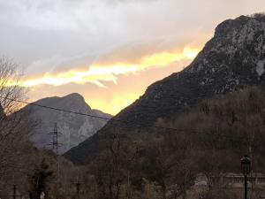 a view of a mountain with a sunset in the background at Apartamento La Mandrágora in Arenas de Cabrales