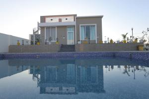 a house with a swimming pool in front of it at Summit Springs Resorts in Bagru