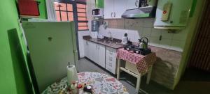 a small kitchen with a table and a refrigerator at OASIS II Las Moras, con cochera y jardin in La Rioja