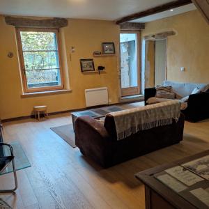 a living room with two couches and a large window at Gîte, Vintage Touch in Hannonville-sous-les-Côtes