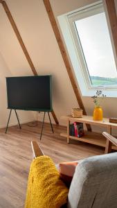 a living room with a tv and a couch at Designer chalet with gorgeous Eifel panorama in Kerschenbach