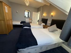 a hotel room with two beds and a mirror at Diamonds Guest House in York
