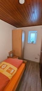 a small bedroom with a bed and a window at Ferienwohnung Glashauser in Biedenkopf +1 photo