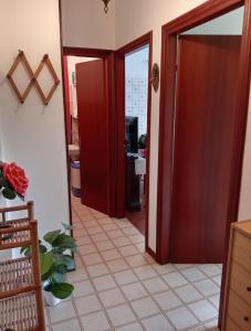 a hallway with red doors and a tile floor at Grazioso bilocale in Giusvalla