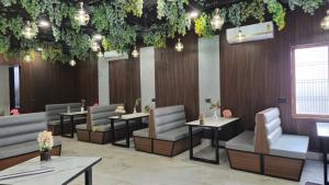 a dining room with tables and chairs and plants at Shri banke bihari complex in Jalesar