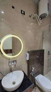 a bathroom with a sink and a mirror and a toilet at Shri banke bihari complex in Jalesar