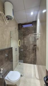 a bathroom with a toilet and a glass shower at Shri banke bihari complex in Jalesar