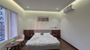 a bedroom with a bed and two chairs and a window at Shri banke bihari complex in Jalesar
