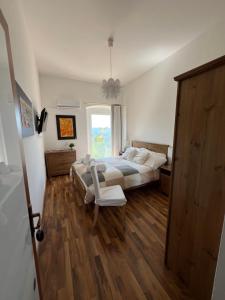 a bedroom with a bed and a chair and a window at Experience Il Paesino in Licodia Eubea
