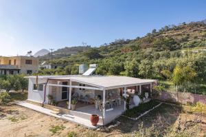 a white house with a hill in the background at Villa Theros in Ierapetra