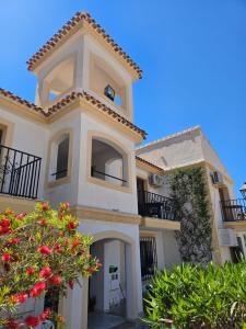 a large white building with balconies and red flowers at Casa Indalo Vera Coast in Vera