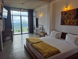 a bedroom with a large bed and a large window at Aroma Holiday Home-Haputhale in Haputale