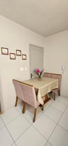 a dining room table with a vase of flowers on it at Apartamento amplo, confortável e central! in Veranópolis