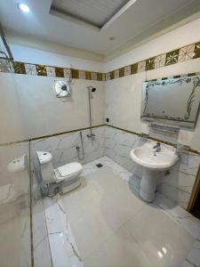 a bathroom with a toilet and a sink at Royal swiss Hotel Khanpur in Khānpur