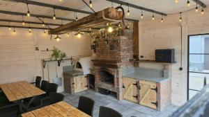 a restaurant with a brick fireplace in a room with tables at Apartamenty pod Dzikowcem in Boguszów-Gorce