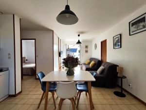 a living room with a table and a couch at Résidence le safran in Erdeven