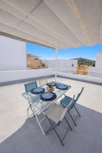 a glass table and chairs on a roof at Casa Del Sol in Águilas