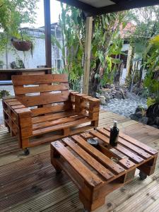 two wooden benches sitting on a wooden deck at Chambre indépendante in Basse-Terre