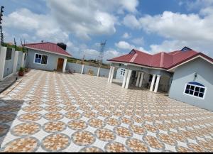 a house with a tile driveway in front of it at Modern Way Guesthouse in Kasoa