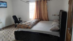 a bedroom with a bed with a window and a desk at Modern Way Guesthouse in Kasoa