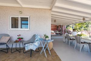 a patio with chairs and tables and a dining room at Villa Theros in Ierapetra