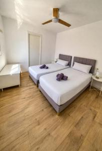 two beds in a room with wooden floors at Casa Del Sol in Águilas