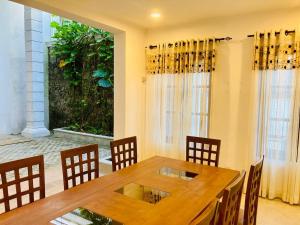 a dining room with a wooden table and chairs at Sky Mansion Athurugiriya in Athurugiriya