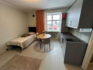 a small room with a bed and a table and a kitchen at Villa Karijoki in Karijoki