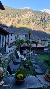 a patio with chairs and a table with a mountain in the background at B&B Lostallo Beat and Bloom in Lostallo