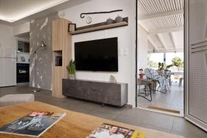 a living room with a flat screen tv on a wall at Villa Theros in Ierapetra