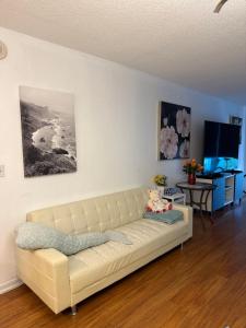 a living room with a white couch and a tv at Apartments TVG Miami by the ocean ! in Miami Beach