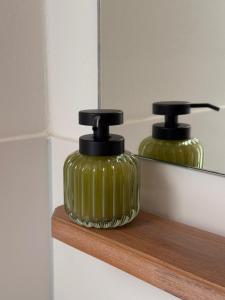 two green glass bottles sitting on a wooden shelf at Ferienhof Vielstedt in Schürenbusch +18 photos